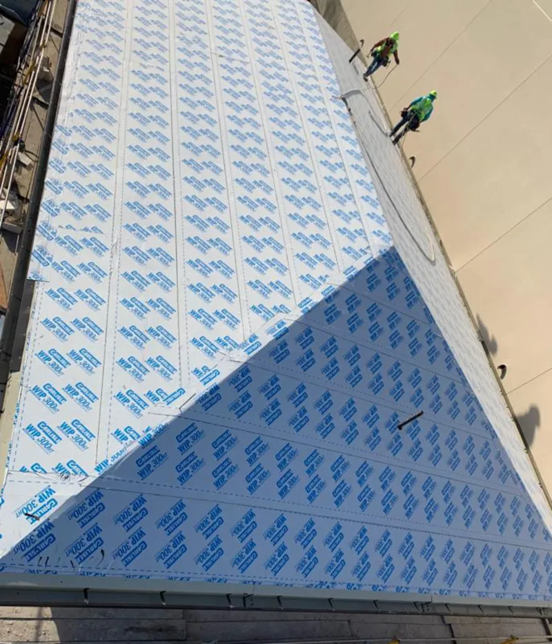 Professional roofers installing underlayment on a metal roof in Lake Forest Park